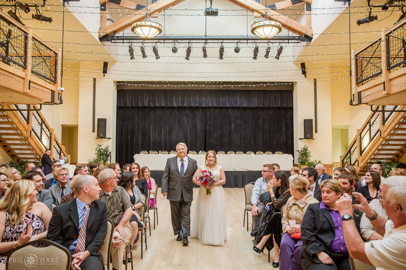Bride walks down aisle at her indoor wedding ceremony at Silverthorne Pavilion