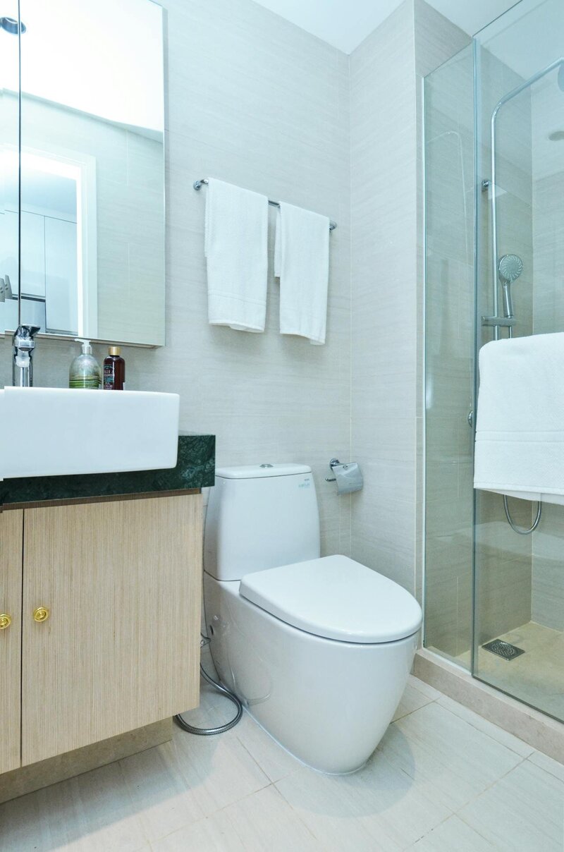 a white toilet next to a shower in a bathroom 
