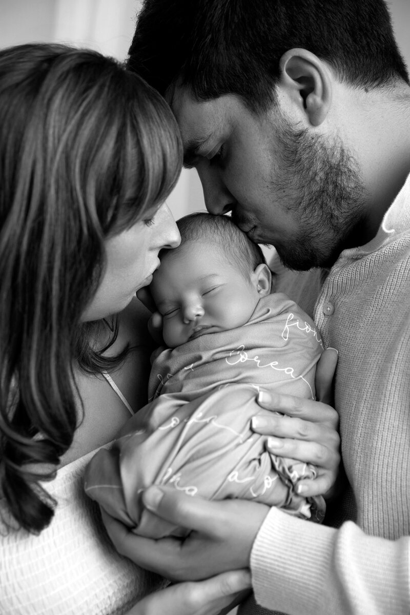 Family smiling and laughing with toddler.  Mother with baby bump.