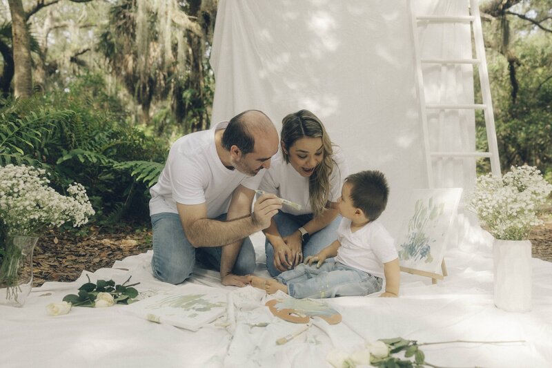 family paints a picture with their son