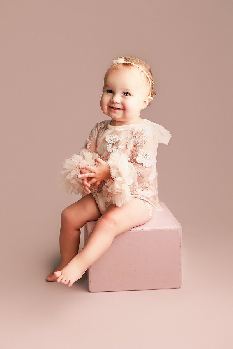 Close-up of baby girl wearing delicate headband in studio milestone photo