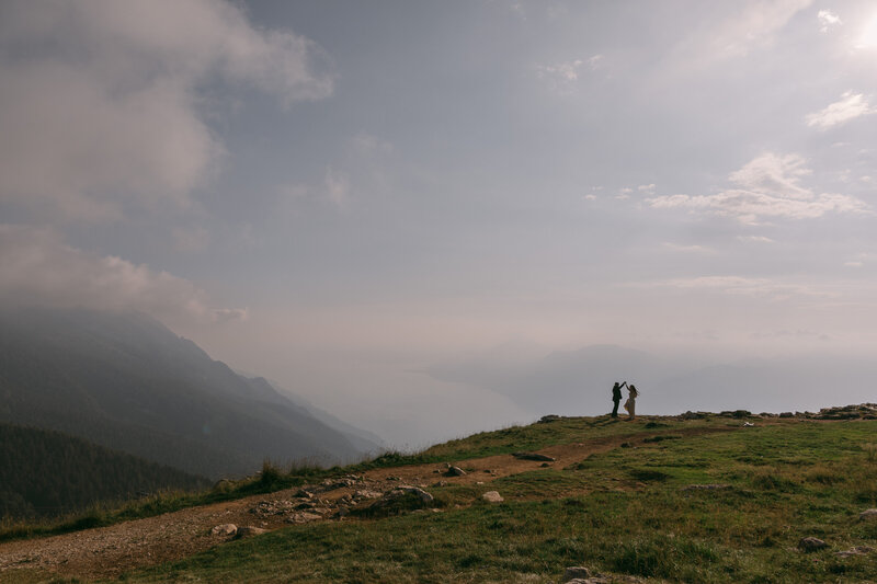 bride and groom in the distance with mountains in the background