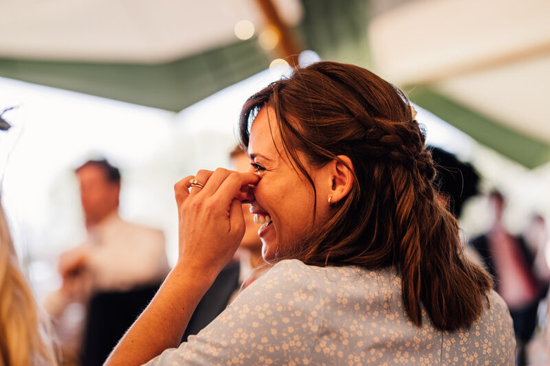Close up of wedding guest laughing and enjoying reception