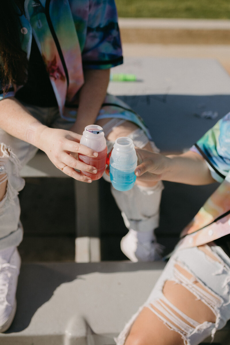 A red and blue juice box being clinked.