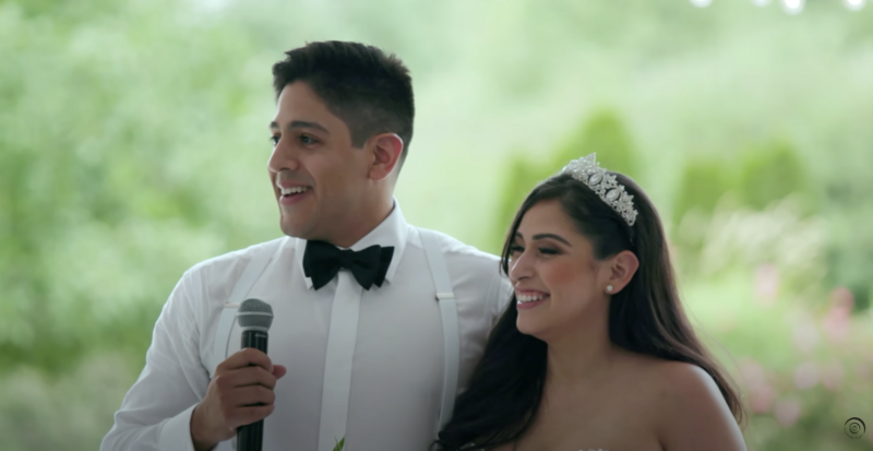 groom holding microphone while bride smiles