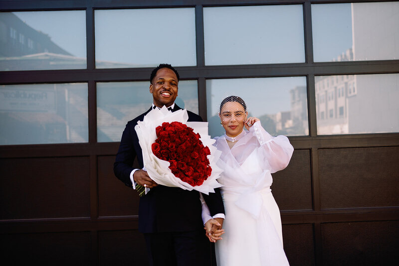 bride and groom with bouquet of red roses wedding portraits