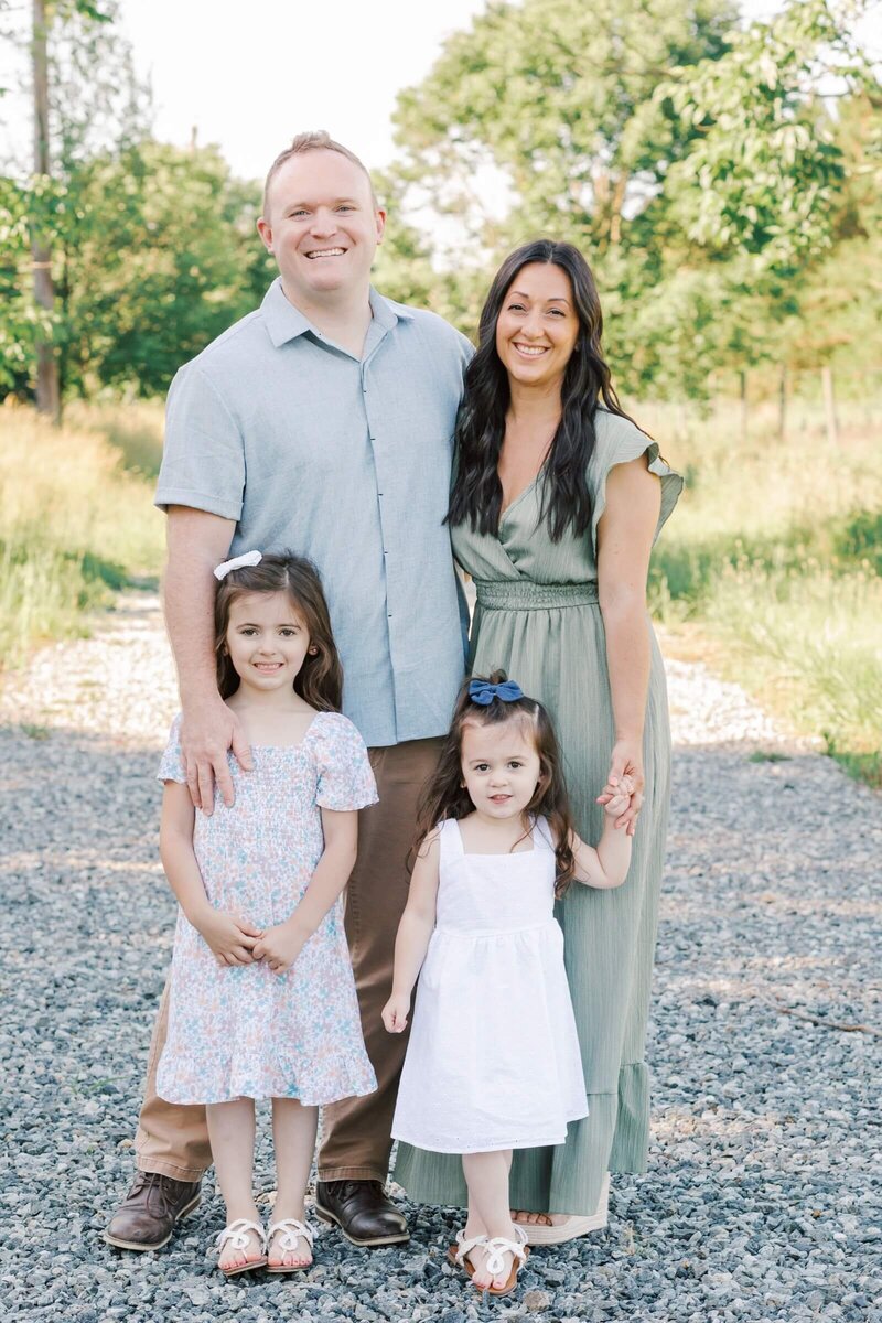 A family of 4 stands on a gravel path during their New Jersey Family Photo Session