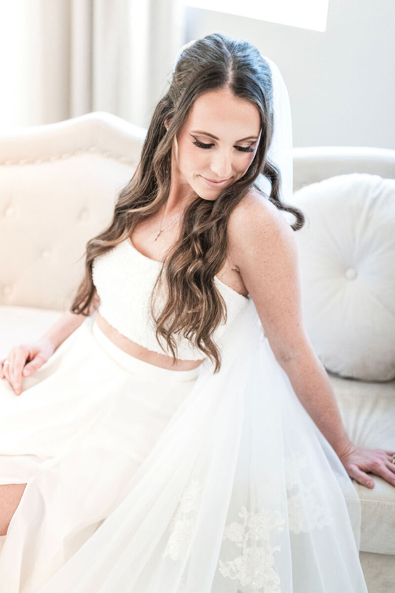 Bride in white wedding dress on sofa