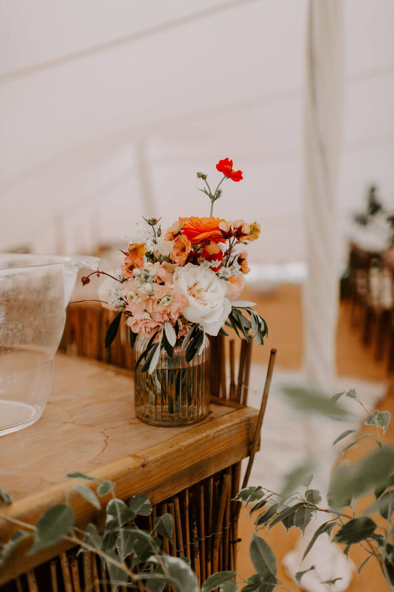 VASE OF ORANGE FLOWERS FOR A WEDDING MARQUEE WEDDING