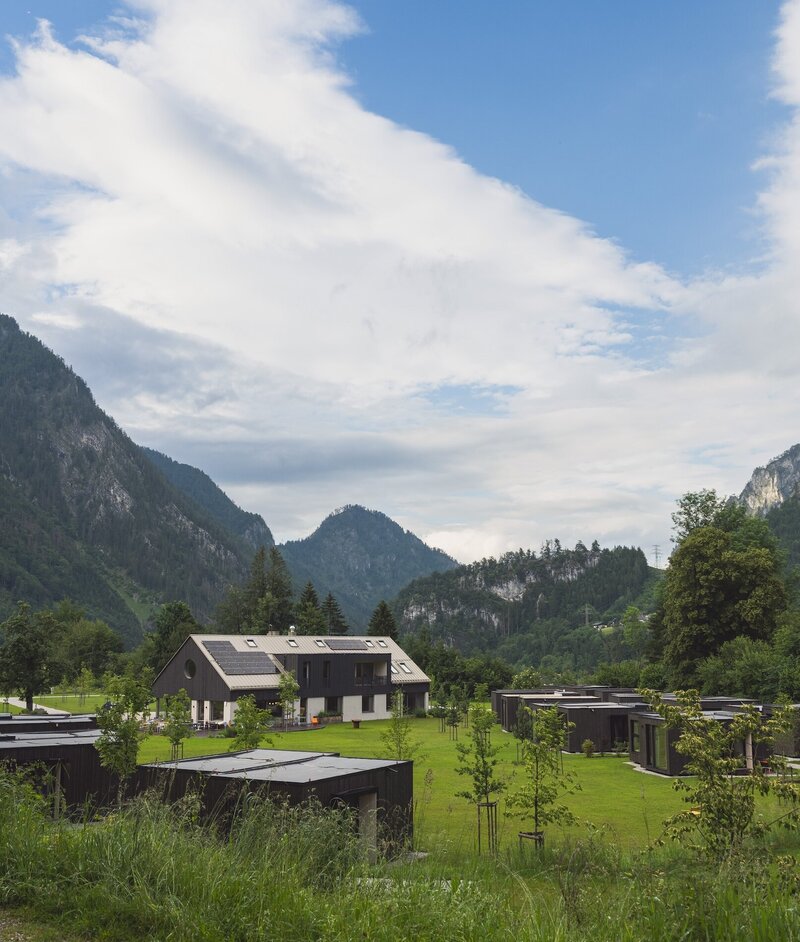 View of The Campus and charming Tiny Homes surrounded by stunning Alpine scenery, offering a unique accommodation experience for private getaways and company retreats at The Campus Alps.com.
