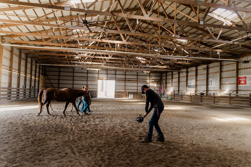 video producer eli ommen operates a camera gimbal in an  equine arena