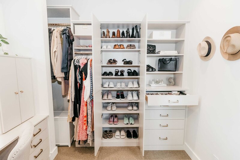 A closet featuring organized shoes, clothes and accessories