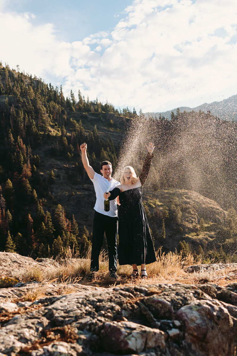 Couple sprays champagne to celebrate their engagement in Ouray, Colorado.