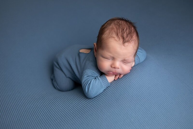 newborn boy in blue outfit