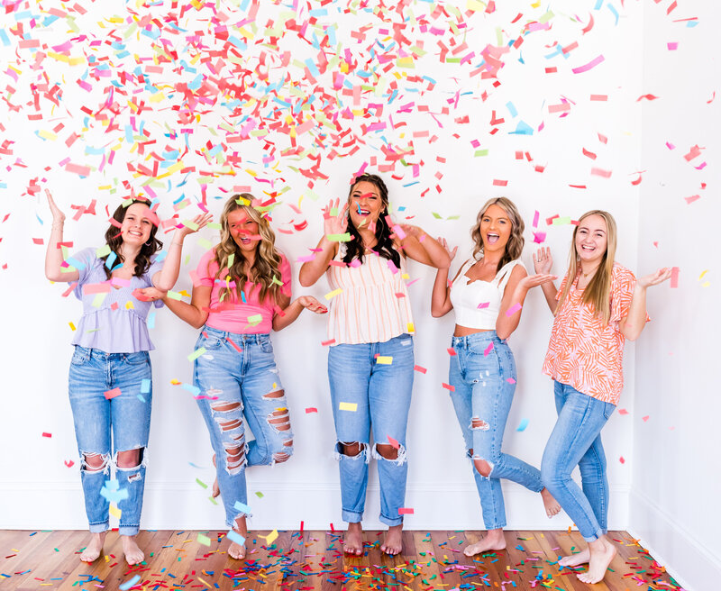 High school girls celebrating senior year with confetti pop