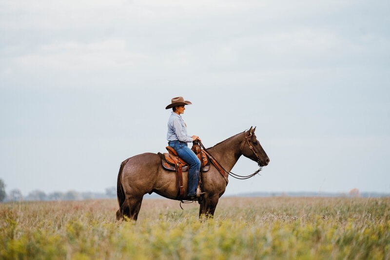 Western riding style out in the pasture checking cows