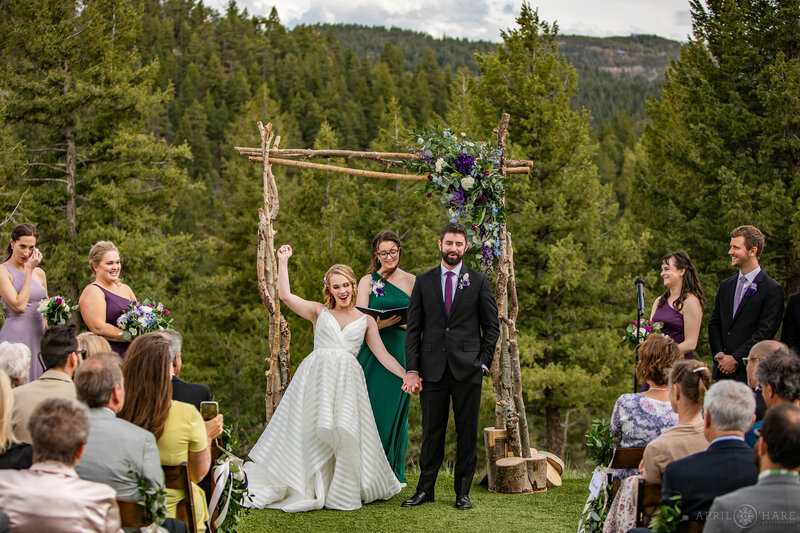 Couple Celebrates at the End of their Wedding Ceremony on the Lawn at The Woodlands Barn in Colorado