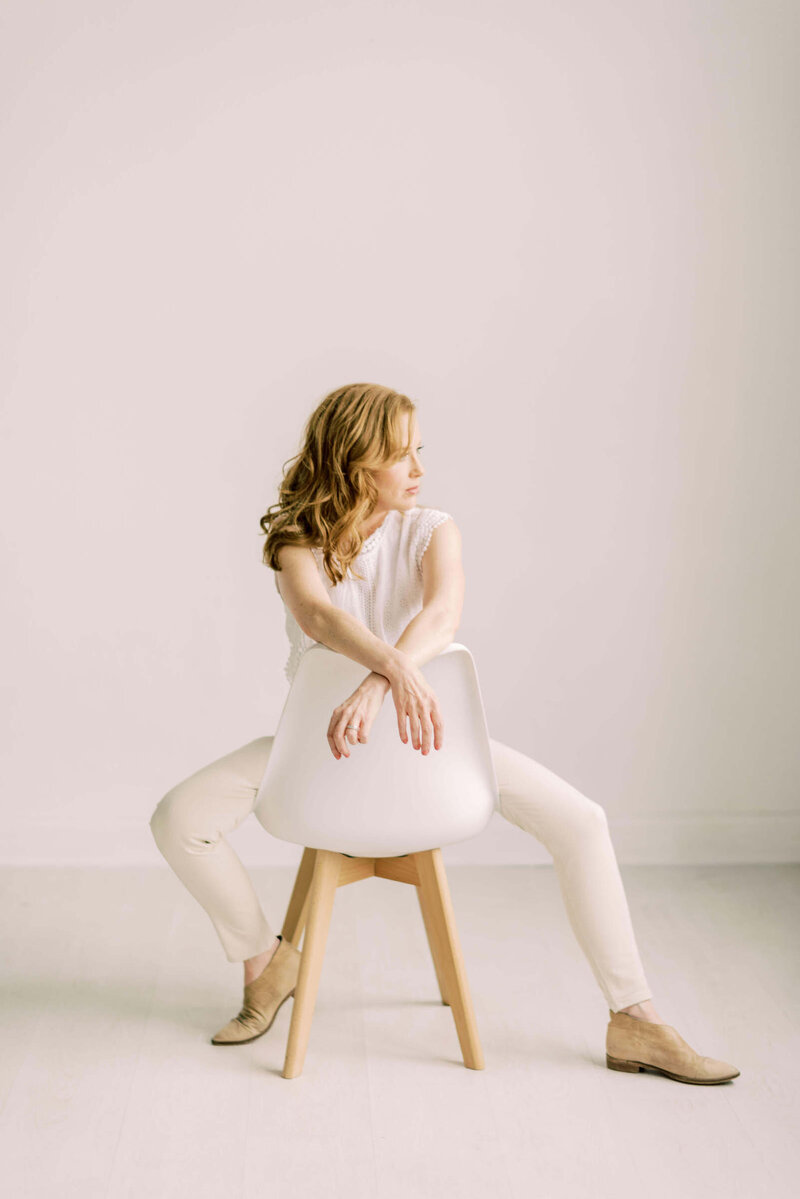 Kate Panza north Texas wedding photographer wearing white sitting on white chair