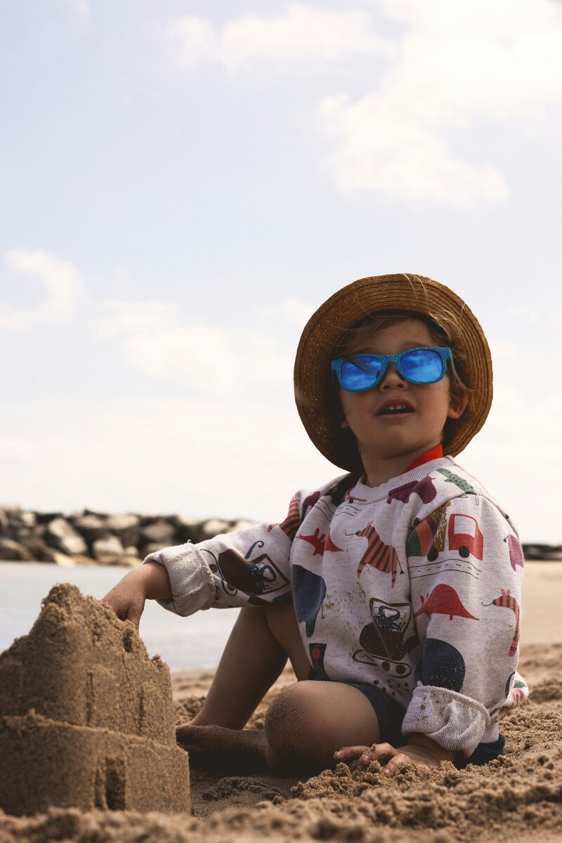 boy building sandcastle on beach