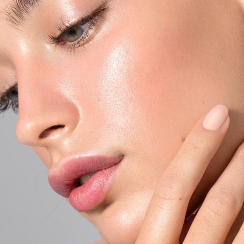 Woman with clear skin and slight blush looking down