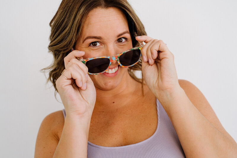 Jess Collins headshot smiling with sunglasses