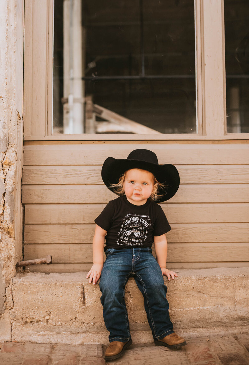 toddler boy in a black Johnny Cash t-shirt with cowboy boots and a black cowboy hat in ft worth stockyards
