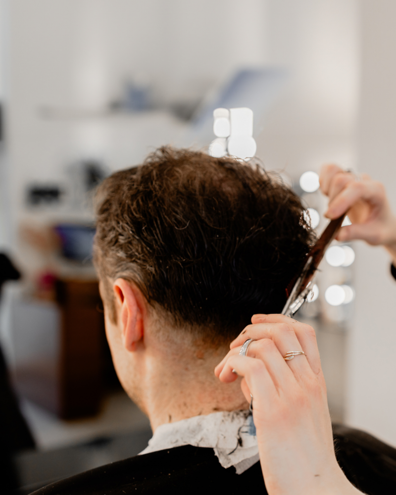Friseur schneidet einem Mann die Haare