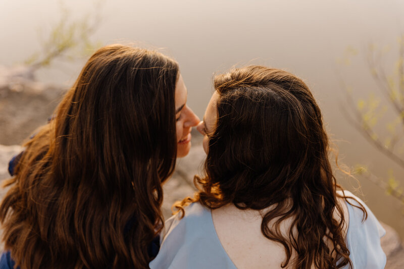 A couple sitting next to each other about to kiss