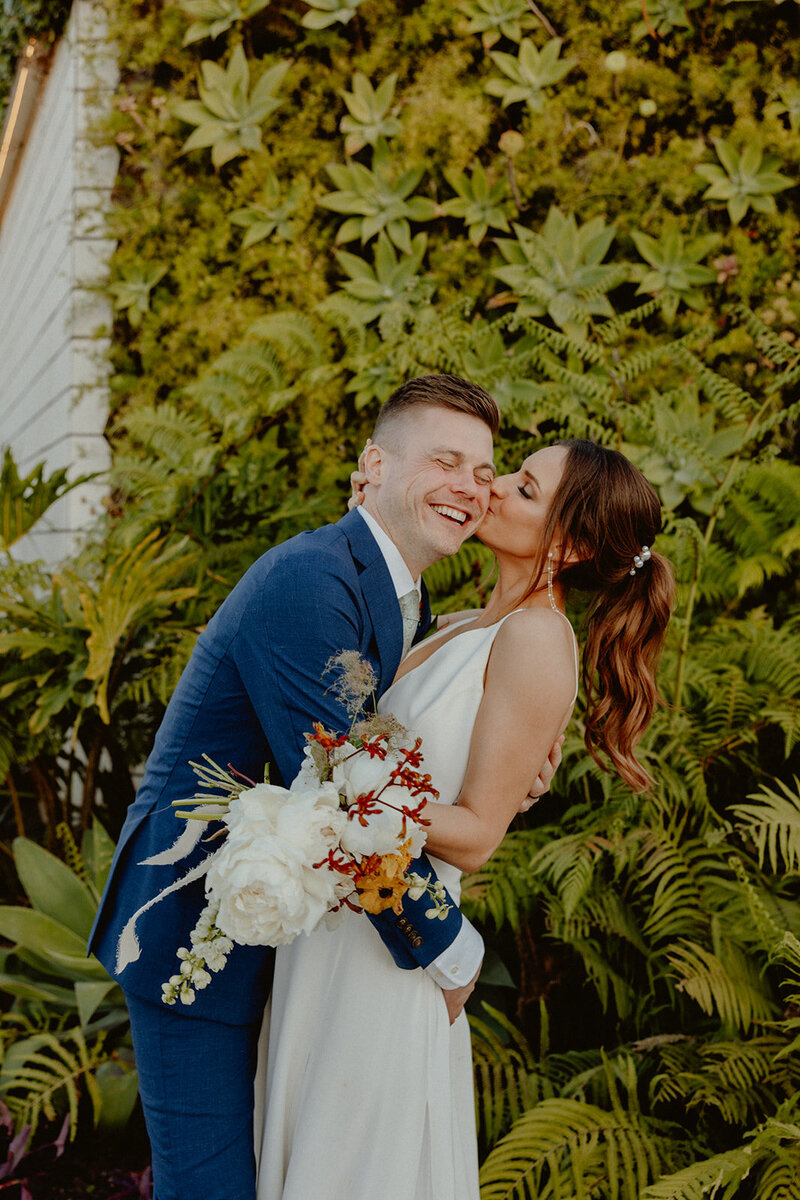 big sur engagement couple kiss on cliff