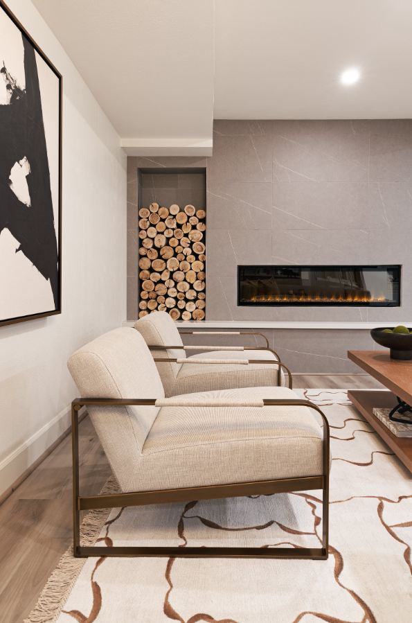 Modern mountain living room with plush textures and a stone fireplace with styled wood accent wall, designed by Sister Studio.