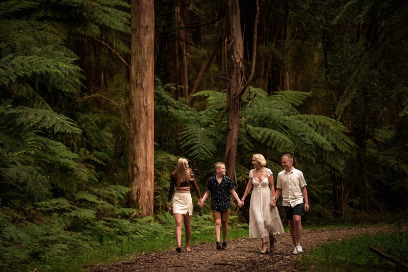 family of four photographed walking treefern lined path at Kallista