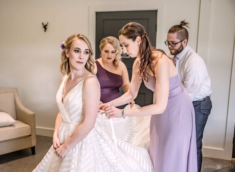 Bride Getting help with her Dress in the Bridal Suite at The Woodlands Barn in Colorado