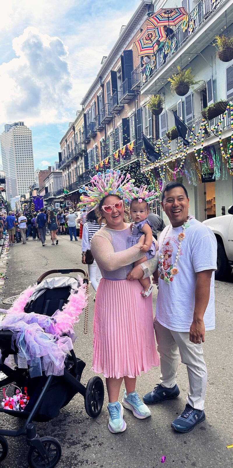 Olivia Yuen and her family celebrating at a vibrant street festival, with colorful decorations and confetti in the background.