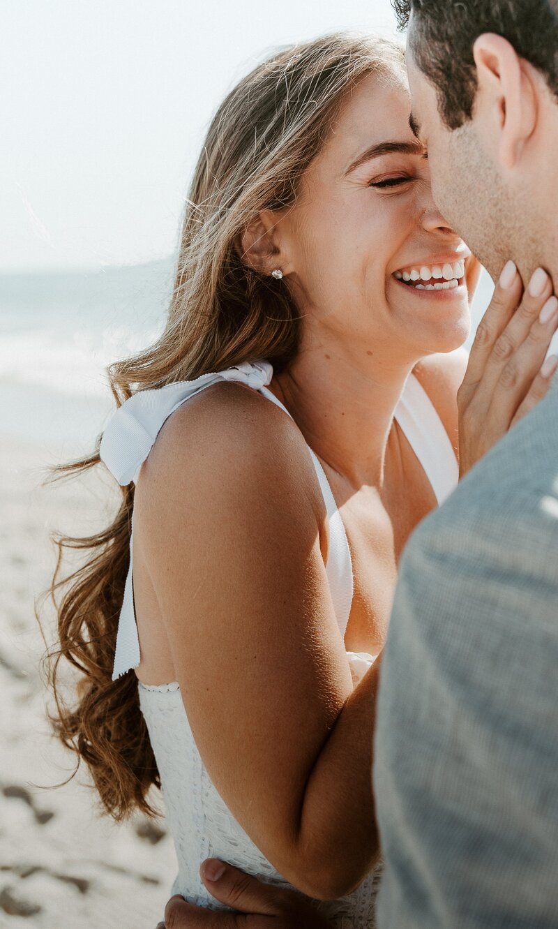 Bride smiling at groom on beach in Los Angeles