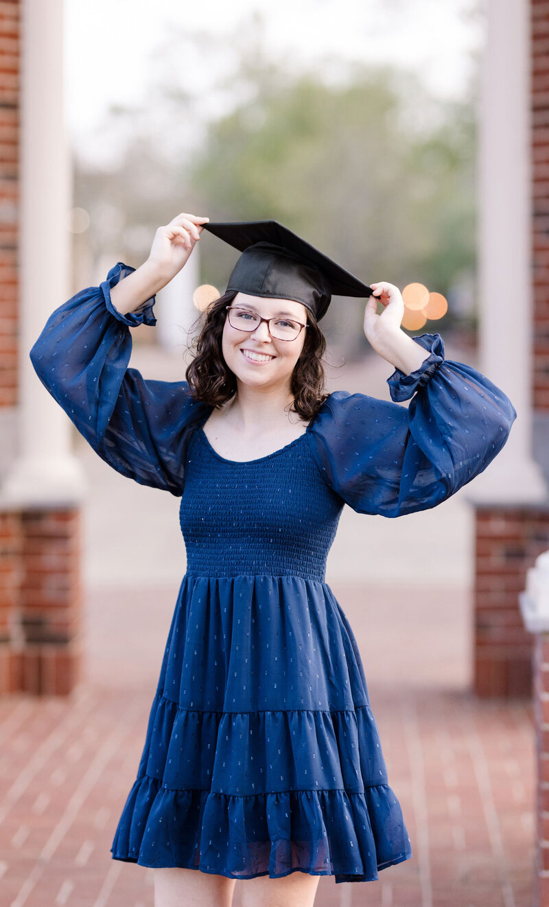 Lee University senior holding her graduation cap during photos