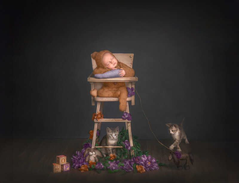  "A peaceful newborn sleeping in a high chair while playful kittens frolic on the ground nearby, captured in a heartwarming and whimsical fine art photography session in Ottawa."