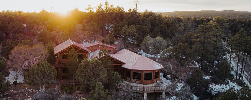 A group of women sit around a dining table smiling. 