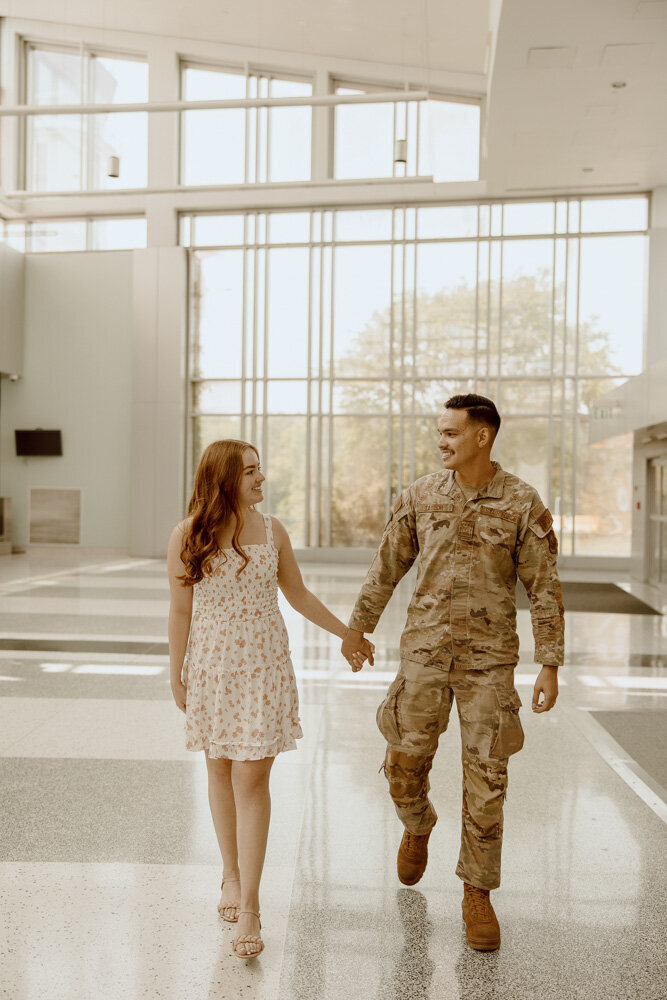 Military couple walks and smiles after being reunited