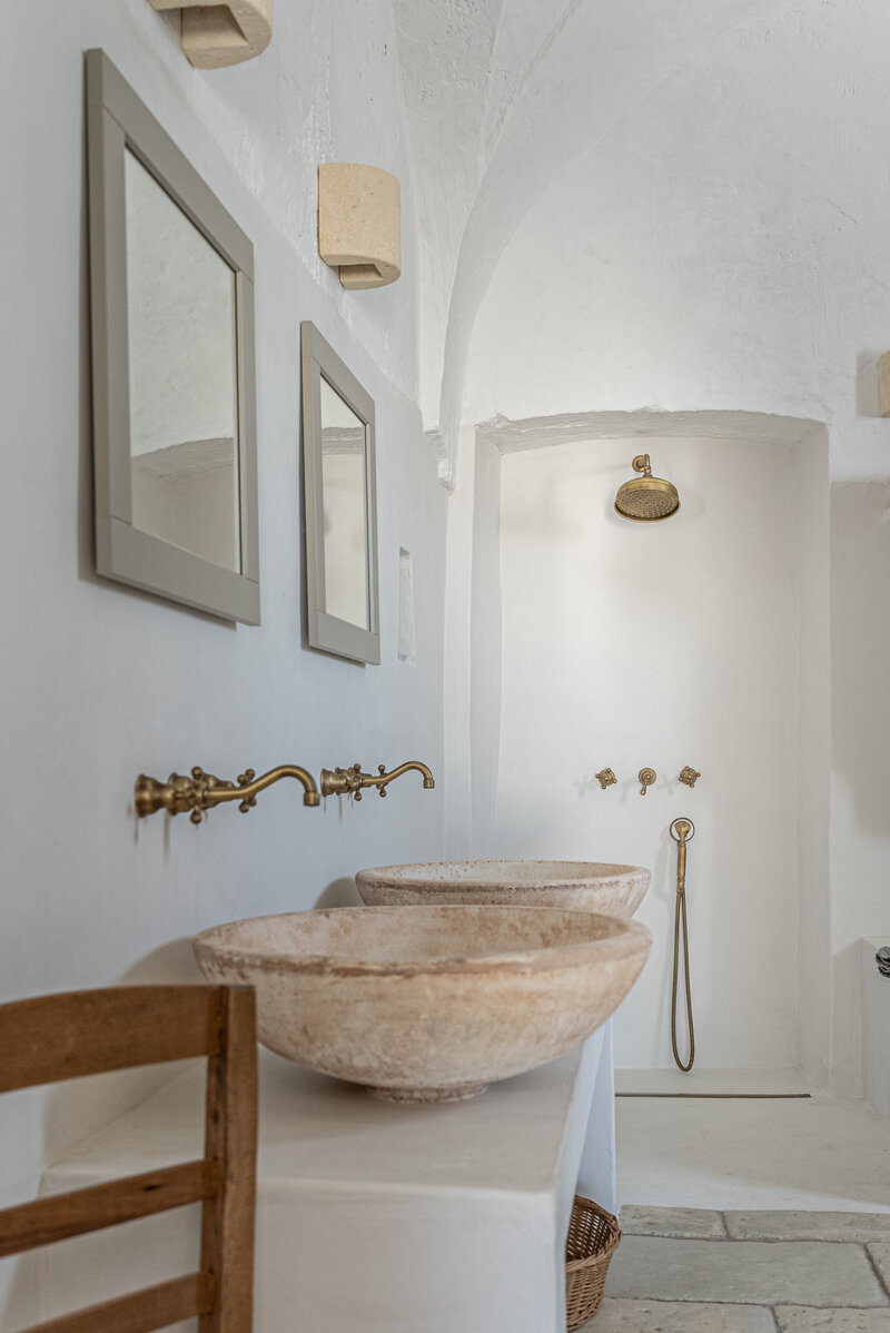 White Italian hotel with arched doorways and pots out front
