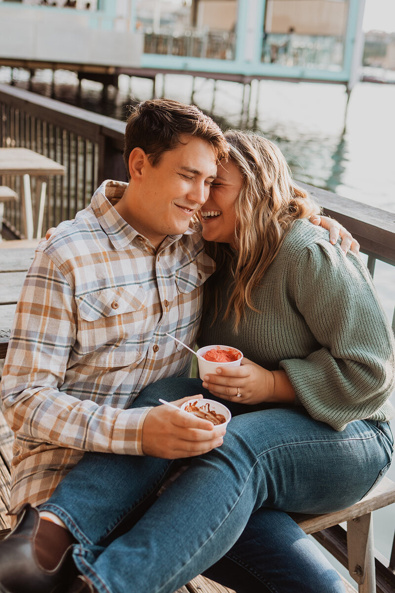 A couple eats ice cream during their Austin engagement photo session at Mozarts Coffee