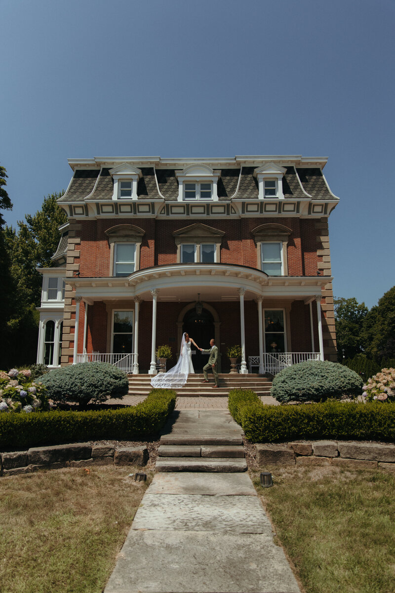 bride and groom kissing in front of window