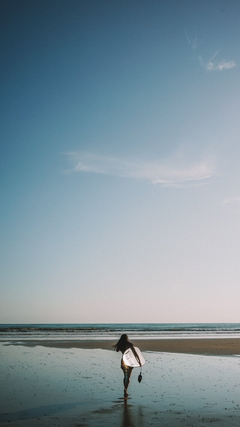 surfer walking to ocean