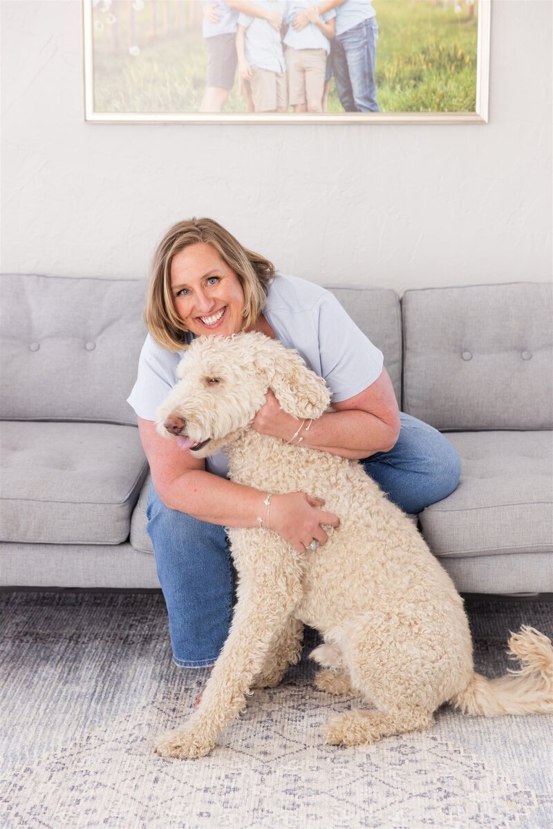 Boise photographer Tiffany Hix hugging her dog at her photography studio in Boise, Idaho.