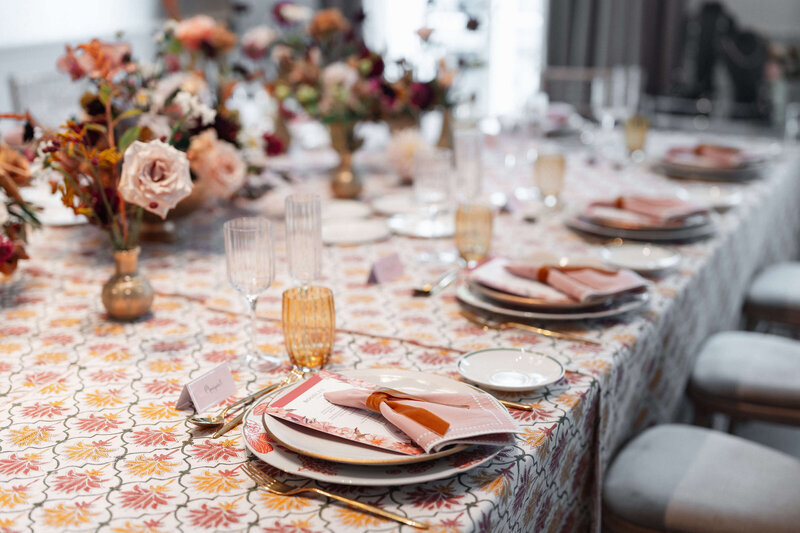 luxury autumnal event table set up with pink and orange patterned table linen and pink napkins from maison margaux
