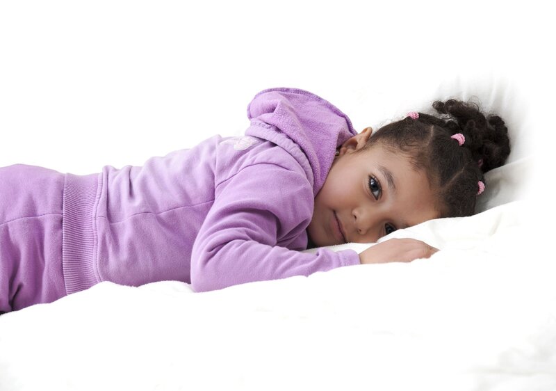 toddler laying on their stomach in a bed