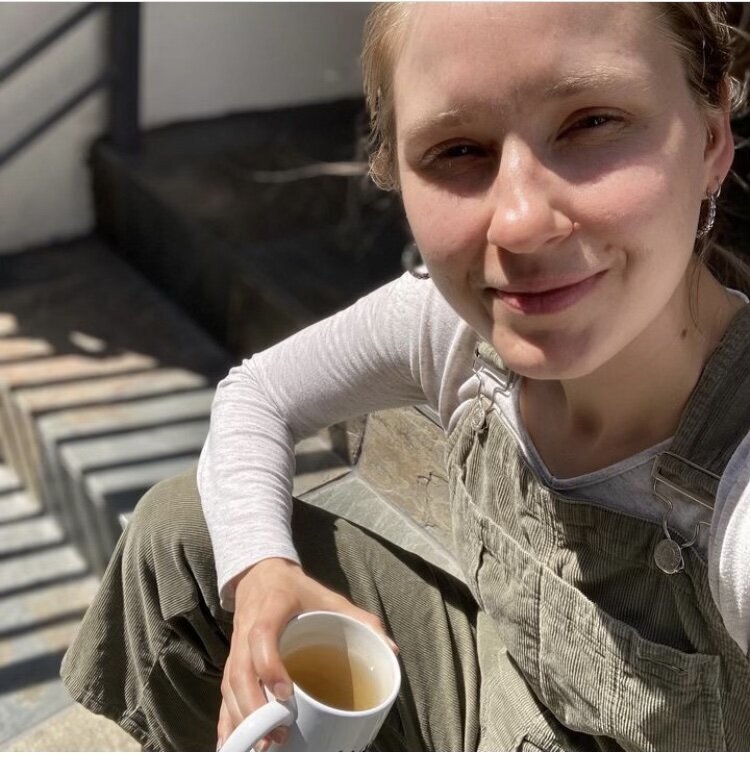 image of laptop and latte in a mug on a wooden table in a bright coffee shop