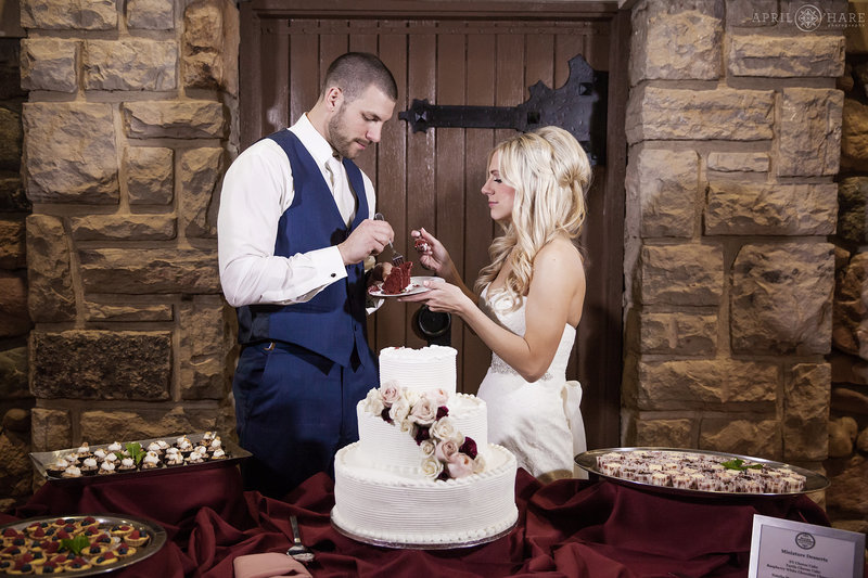 Couple cuts their cake inside the remodeled Great Room former Carriage House at Highlands Ranch Mansion