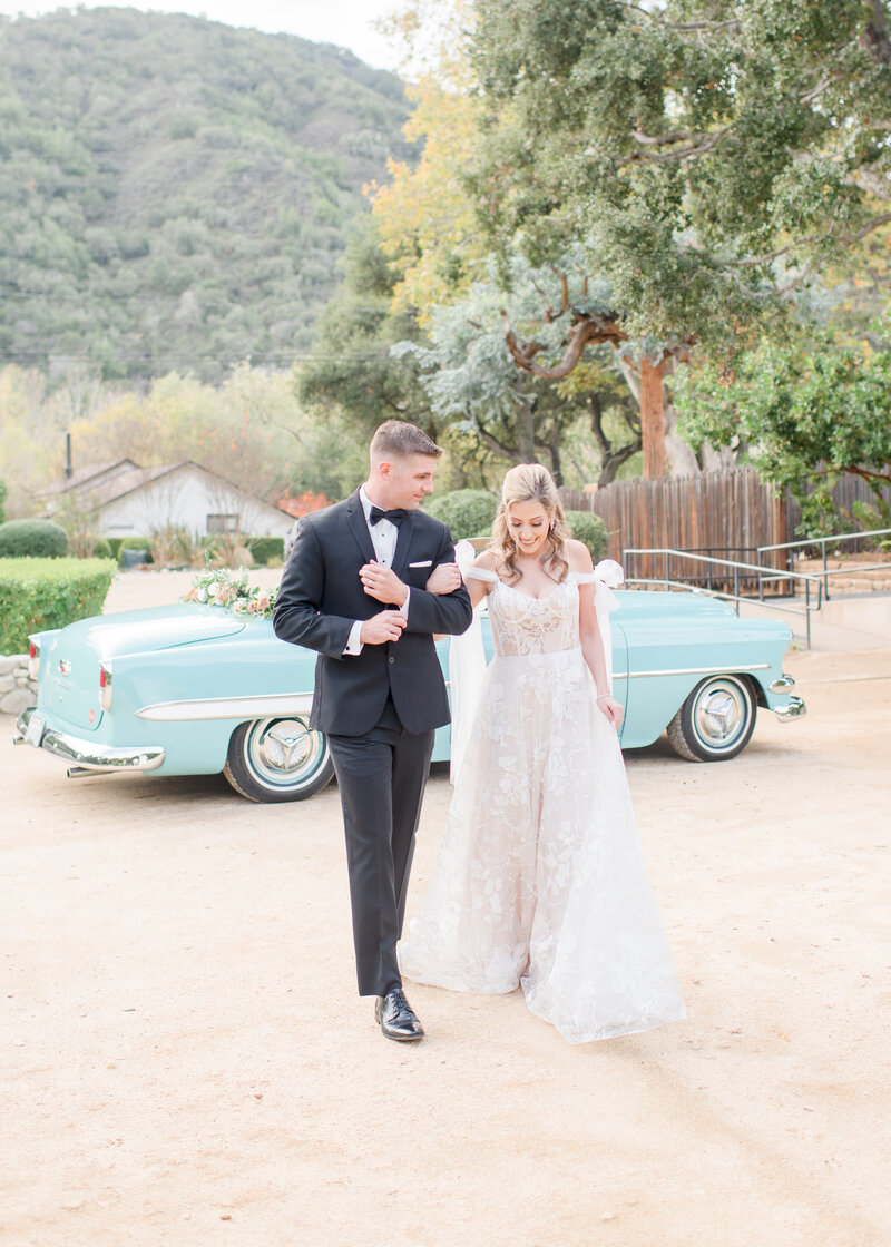 Wedding Photographer, Groom leans into bride sweetly, she smiles in her wedding dress and with bouquet