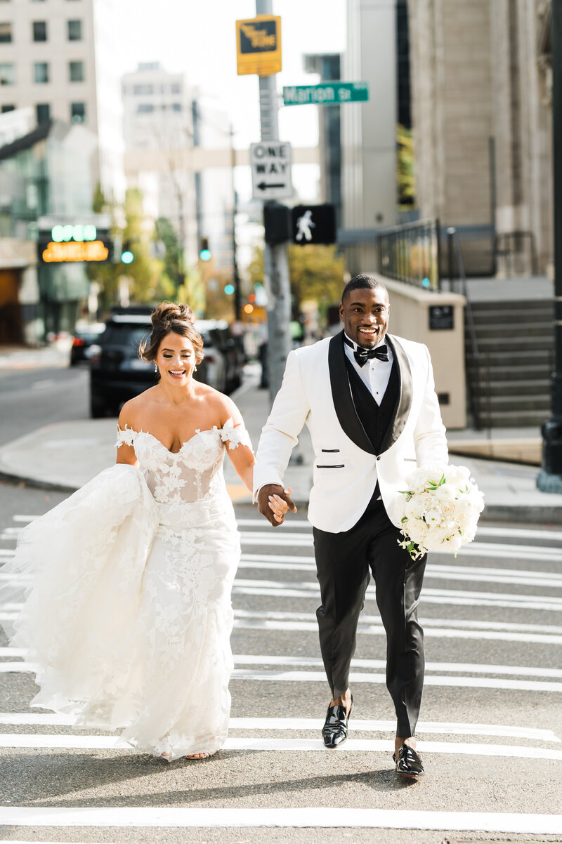 stunning  interracial wedding couple run across seattle street