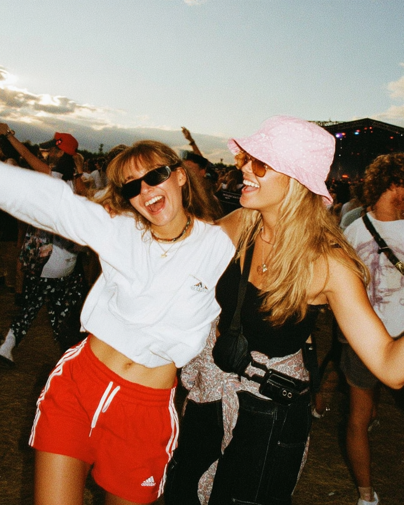 Two girls dancing and smiling at a music festival
